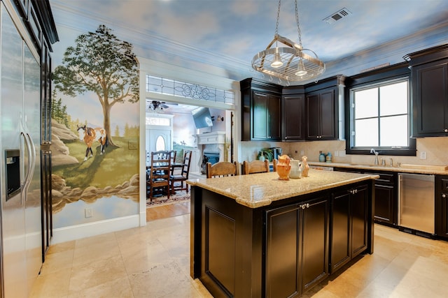 420 Heights Blvd, Houston, TX 77007 - kitchen with stainless steel fridge with ice dispenser, crown molding, hanging light fixtures, light stone counters, and a kitchen island