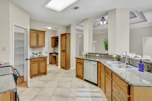 kitchen featuring dishwashing machine, sink, ceiling fan, light tile floors, and a raised ceiling