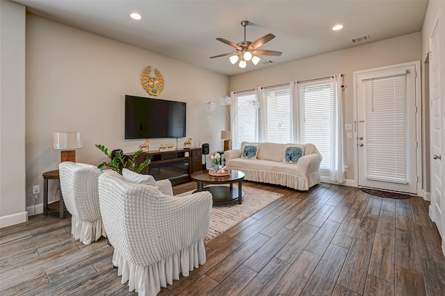 living room with ceiling fan and dark wood-type flooring