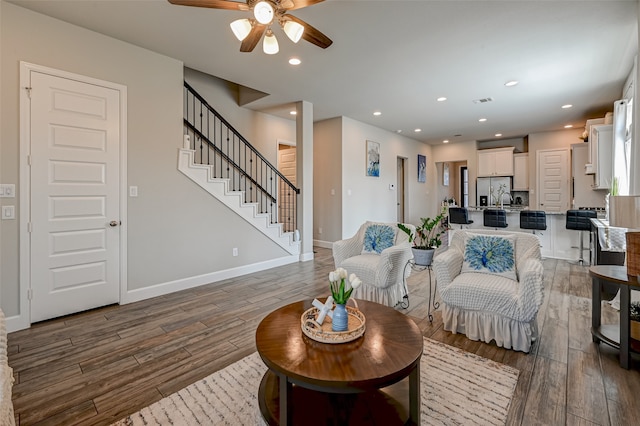 living room featuring ceiling fan and dark hardwood / wood-style floors