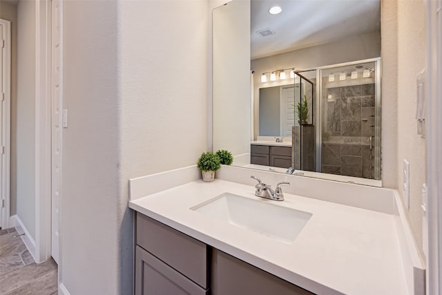 bathroom featuring walk in shower, tile floors, and vanity