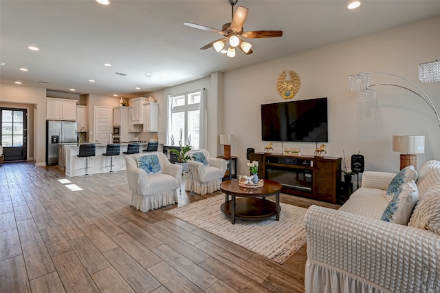 living room with light hardwood / wood-style floors and ceiling fan