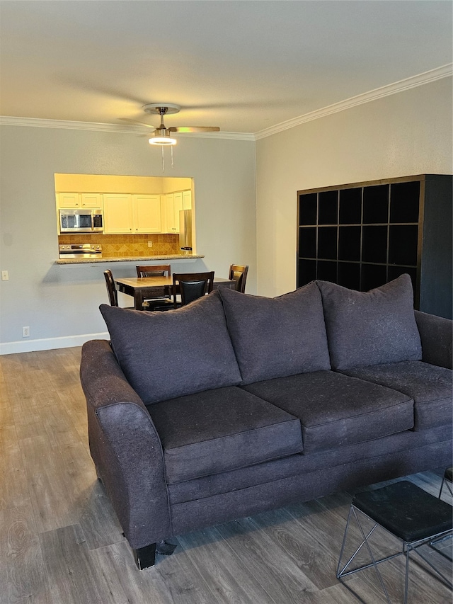 living room with ceiling fan, crown molding, and hardwood / wood-style flooring