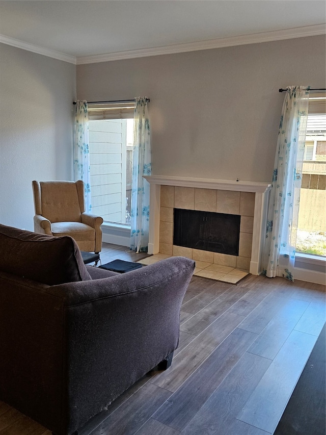 living room featuring ornamental molding, a tile fireplace, and hardwood / wood-style floors