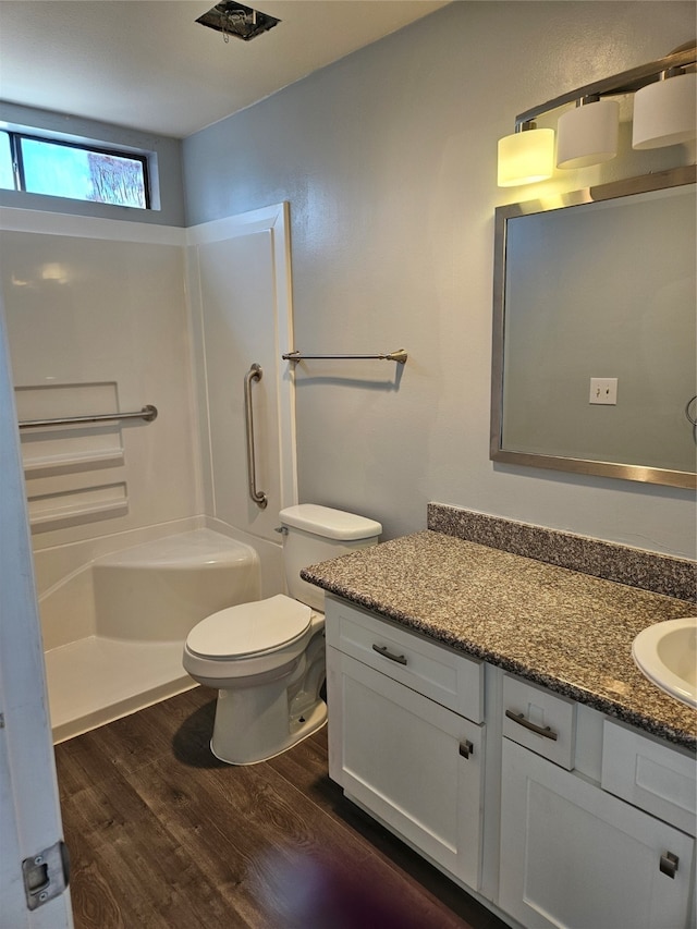 full bathroom with wood-type flooring, vanity,  shower combination, and toilet