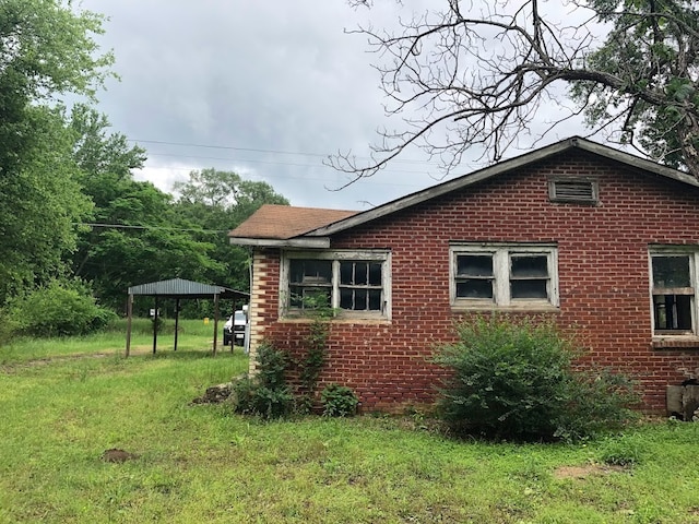 view of side of home featuring a lawn and a gazebo