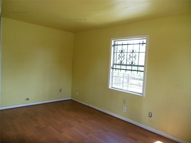 unfurnished room with dark hardwood / wood-style flooring