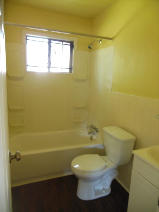 full bathroom with tile walls, toilet, vanity, and bathtub / shower combination