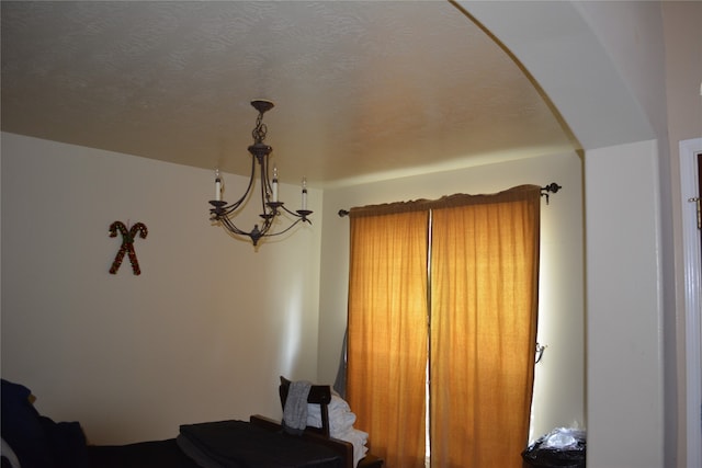 bedroom featuring a notable chandelier and a textured ceiling