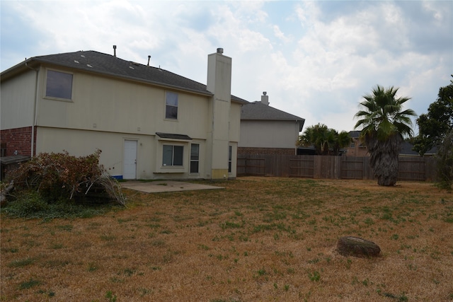 rear view of property with a lawn and a patio area