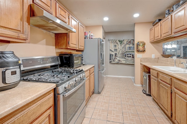 7635 Loro Linda Dr, Houston, TX 77083 - kitchen with under cabinet range hood, a sink, recessed lighting, appliances with stainless steel finishes, and light countertops