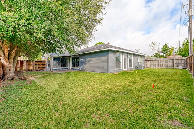 7635 Loro Linda Dr, Houston, TX 77083 - rear view of property with a lawn, central AC, a fenced backyard, and a sunroom