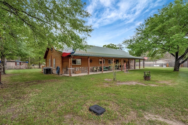 rear view of house with a lawn and central AC