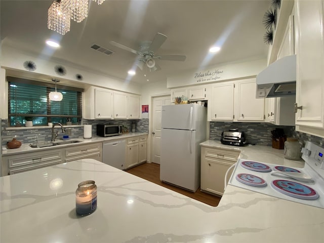 kitchen featuring light stone counters, white appliances, sink, decorative light fixtures, and white cabinetry