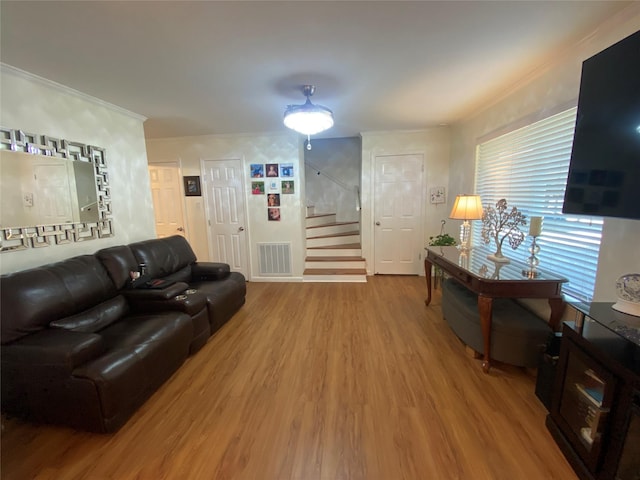 living room with hardwood / wood-style floors and crown molding