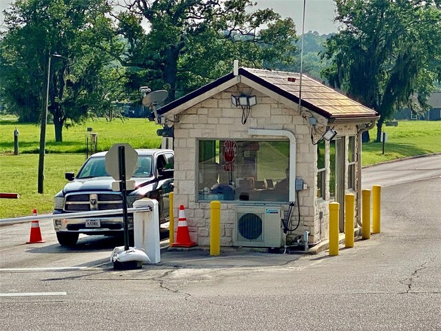 view of outdoor structure featuring a lawn and ac unit