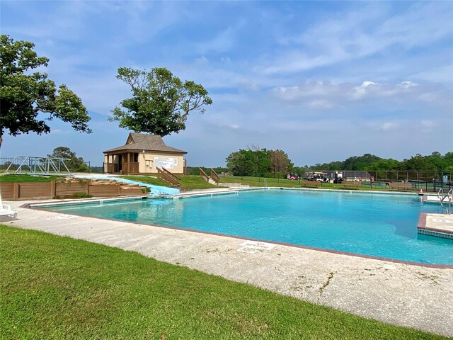 view of swimming pool featuring a lawn