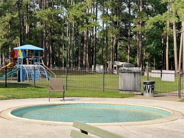 view of swimming pool featuring a yard and a playground