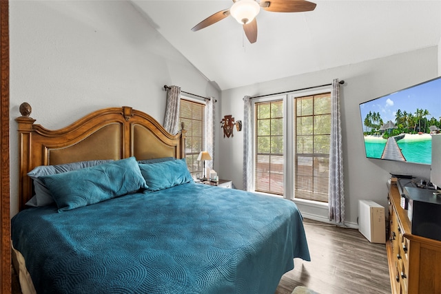 bedroom with ceiling fan, light hardwood / wood-style floors, and vaulted ceiling