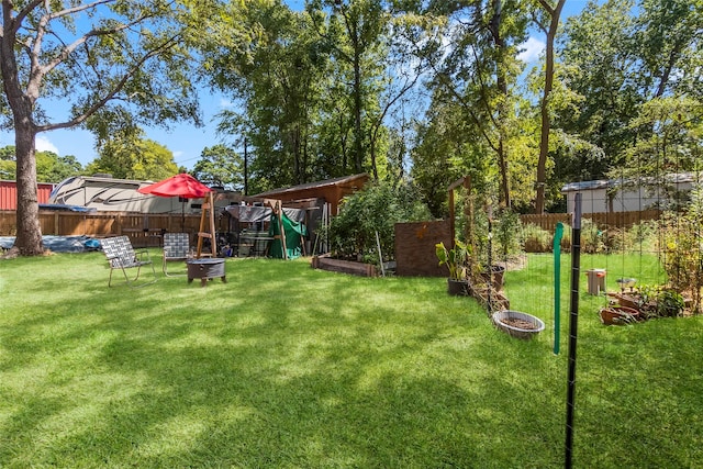 view of yard with a fire pit and a playground