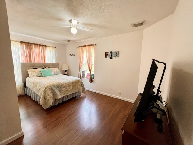 bedroom featuring a textured ceiling, ceiling fan, and dark wood-type flooring