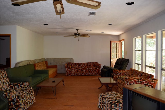 living room featuring a textured ceiling, ceiling fan, and light hardwood / wood-style flooring