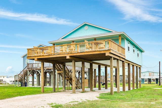 rear view of property featuring a wooden deck and a yard