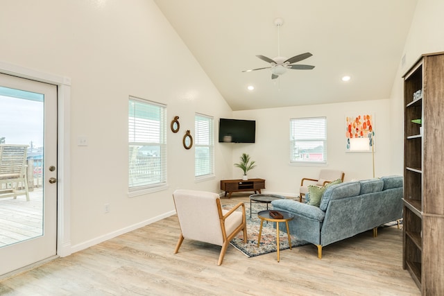 living room featuring ceiling fan, light wood-type flooring, high vaulted ceiling, and a healthy amount of sunlight