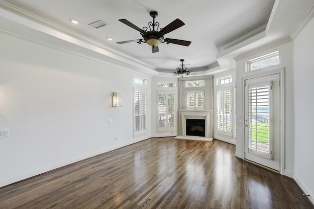 unfurnished living room with ornamental molding, a tray ceiling, ceiling fan, and dark wood-type flooring