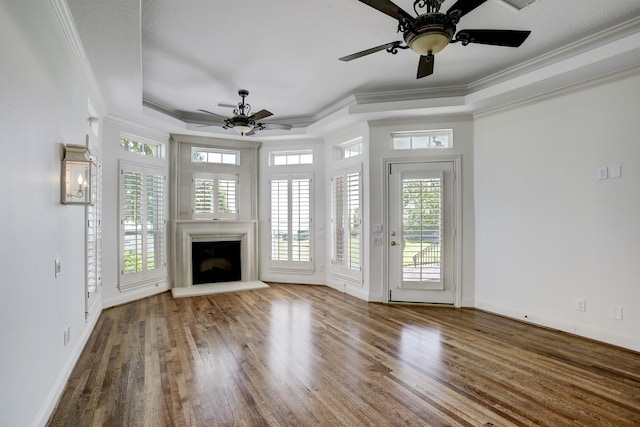 unfurnished living room with a tray ceiling, ceiling fan, hardwood / wood-style floors, and ornamental molding