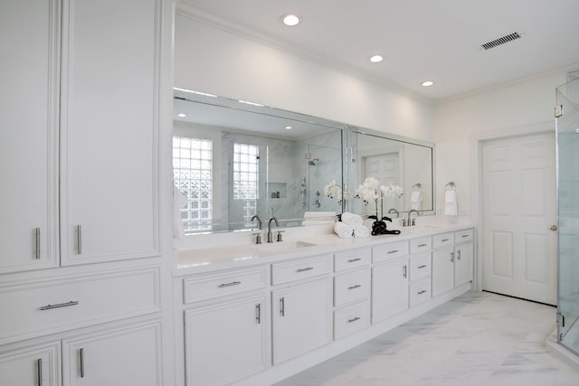 bathroom with vanity, a shower with shower door, and crown molding