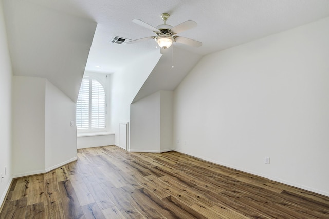 additional living space with hardwood / wood-style flooring, ceiling fan, and lofted ceiling