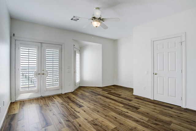 empty room featuring ceiling fan, dark hardwood / wood-style flooring, and french doors