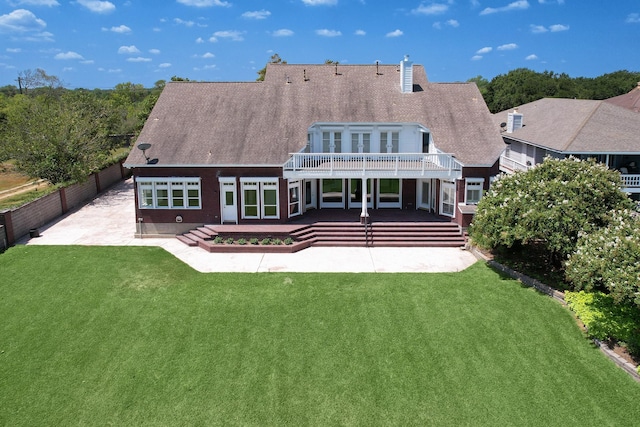 rear view of house featuring a yard, a patio, and a wooden deck