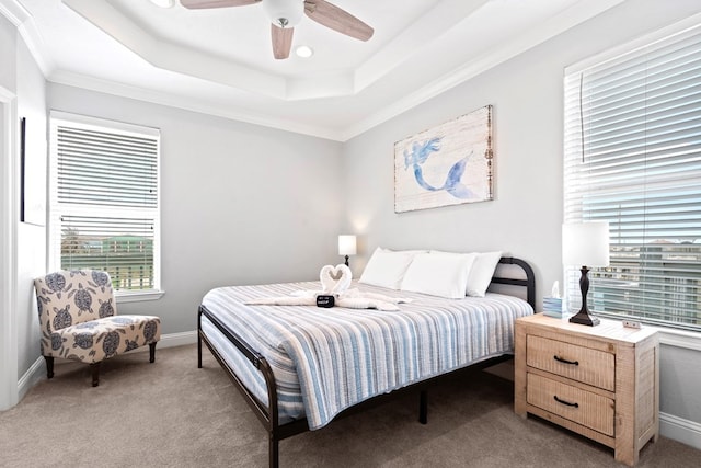 carpeted bedroom featuring a tray ceiling, ceiling fan, and ornamental molding