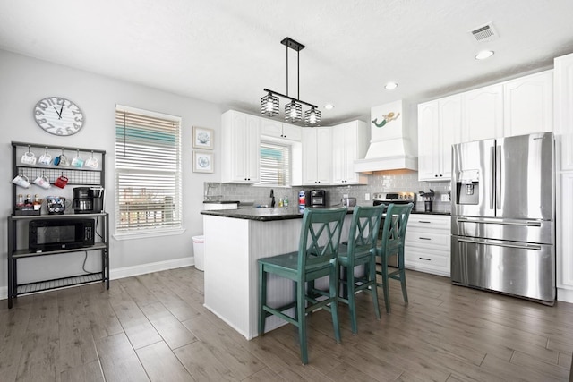 kitchen featuring backsplash, dark hardwood / wood-style floors, custom exhaust hood, white cabinets, and stainless steel refrigerator with ice dispenser