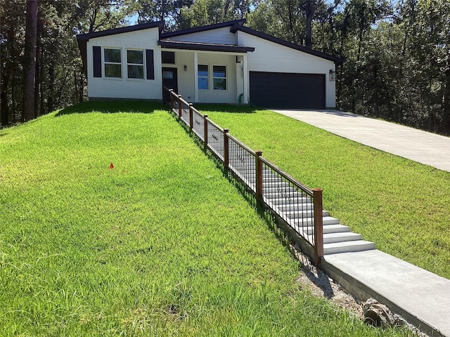 view of front of house with a garage, concrete driveway, and a front yard