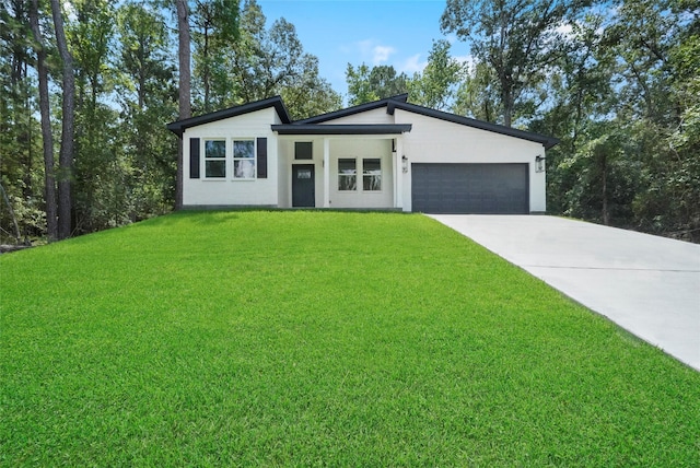 view of front facade featuring a garage, concrete driveway, a front yard, and stucco siding