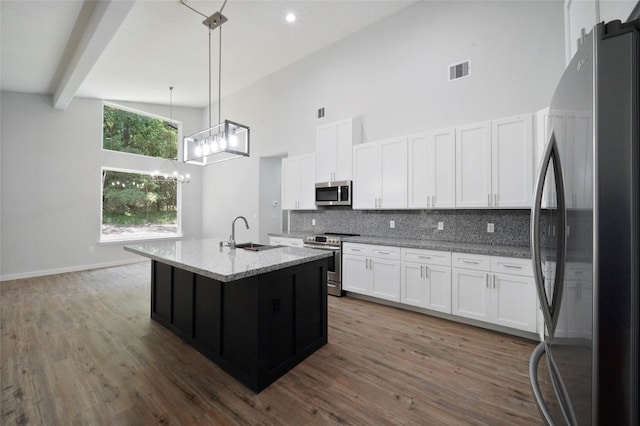 kitchen with tasteful backsplash, visible vents, stainless steel appliances, high vaulted ceiling, and a sink