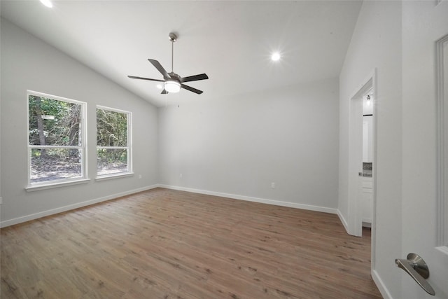 spare room featuring a ceiling fan, wood finished floors, recessed lighting, baseboards, and vaulted ceiling