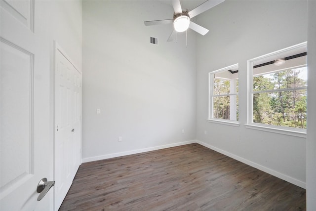 interior space with visible vents, baseboards, wood finished floors, and a ceiling fan