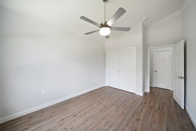 unfurnished bedroom with ceiling fan, a closet, baseboards, and wood finished floors