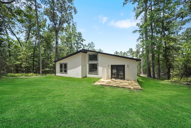 rear view of house featuring french doors and a lawn