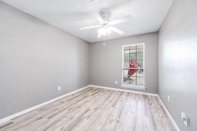 empty room with ceiling fan and light hardwood / wood-style flooring