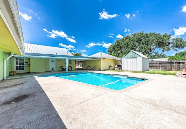 view of pool featuring a shed and a patio area