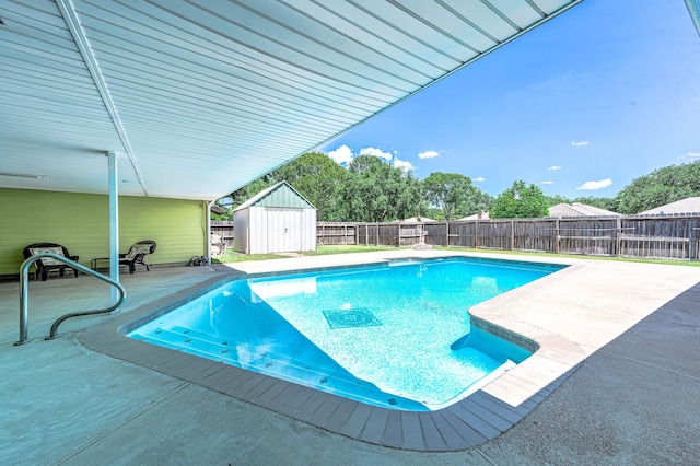 view of swimming pool featuring a patio area and a shed