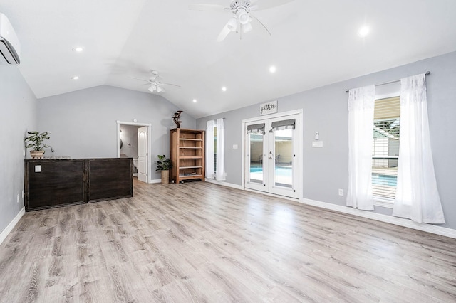 living room with ceiling fan, a wall mounted air conditioner, light wood-type flooring, french doors, and vaulted ceiling