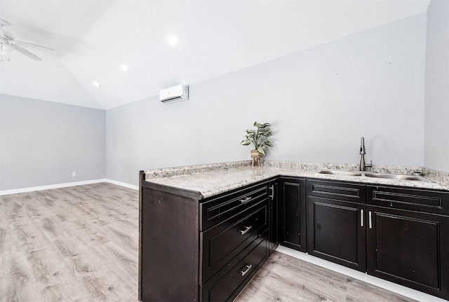 kitchen with ceiling fan, sink, lofted ceiling, and light wood-type flooring