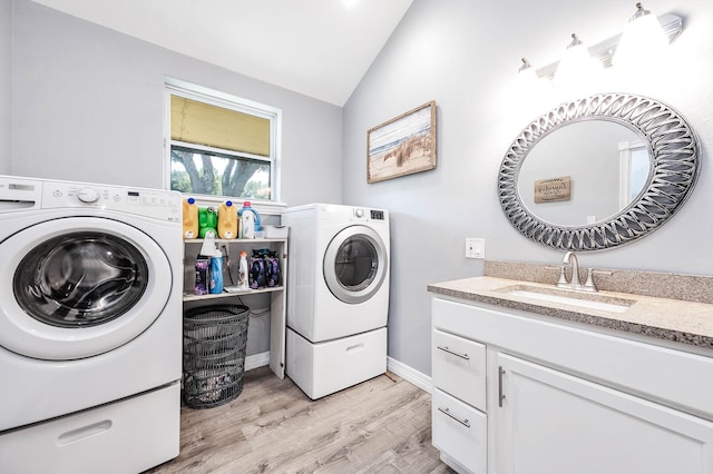 washroom with cabinets, sink, light hardwood / wood-style flooring, and independent washer and dryer