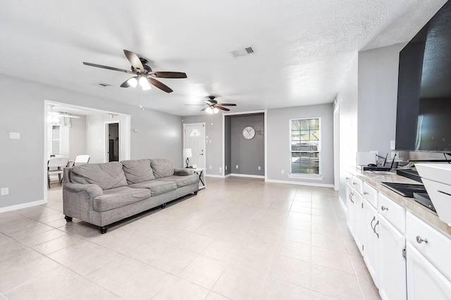 living room featuring ceiling fan and a textured ceiling